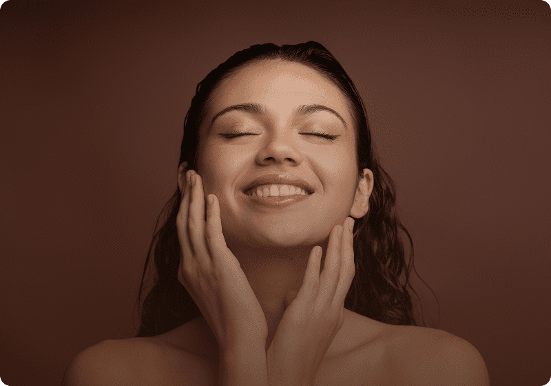 Joyful woman touching her face