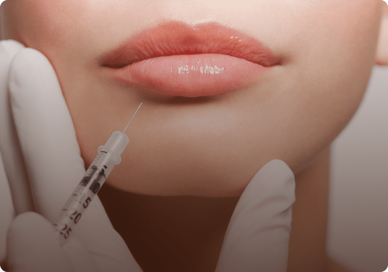 Gloved hands performing lip filler injection