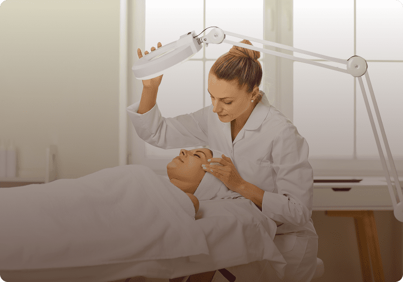 Beauty professional using magnifying lamp